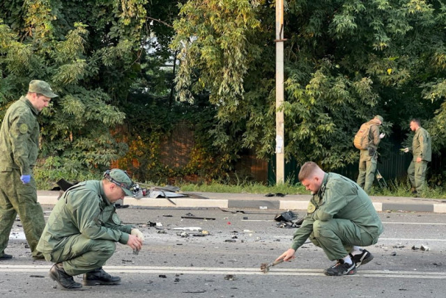 Investigators work at the site of a suspected car bomb attack that killed Darya Dugina, daughter of ultra-nationalist Russian ideologue Alexander Dugin, in the Moscow region, Russia August 21, 2022. (photo credit: Investigative Committee of Russia/Handout via REUTERS)