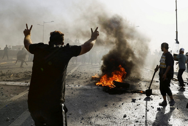 Demonstrators clash with security force during an anti-government protest, after a parliament session, in Baghdad, Iraq September 28, 2022 (photo credit: REUTERS/THAIER AL-SUDANI)
