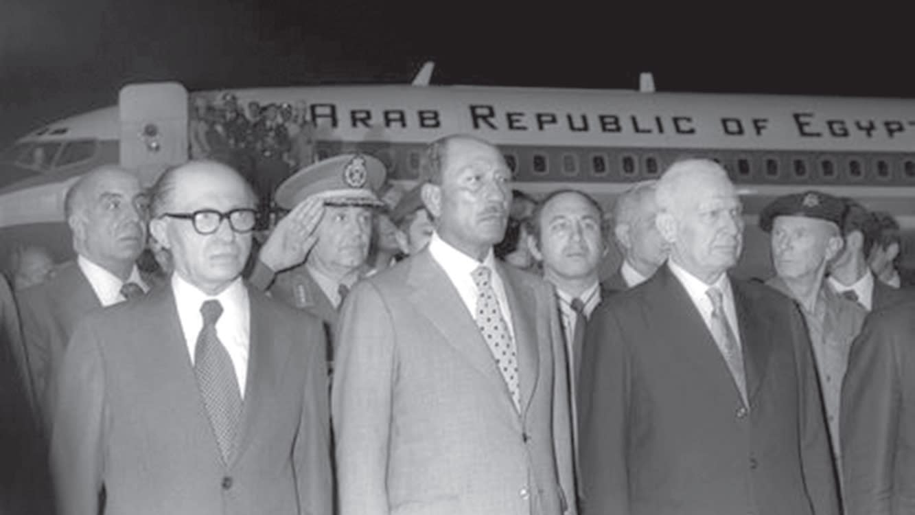 Egyptian President Anwar Sadat and Israeli Prime Minister Menachem Begin stand together at Ben Gurion Airport after Sadat’s arrival on November 19, 1977. (GPO)