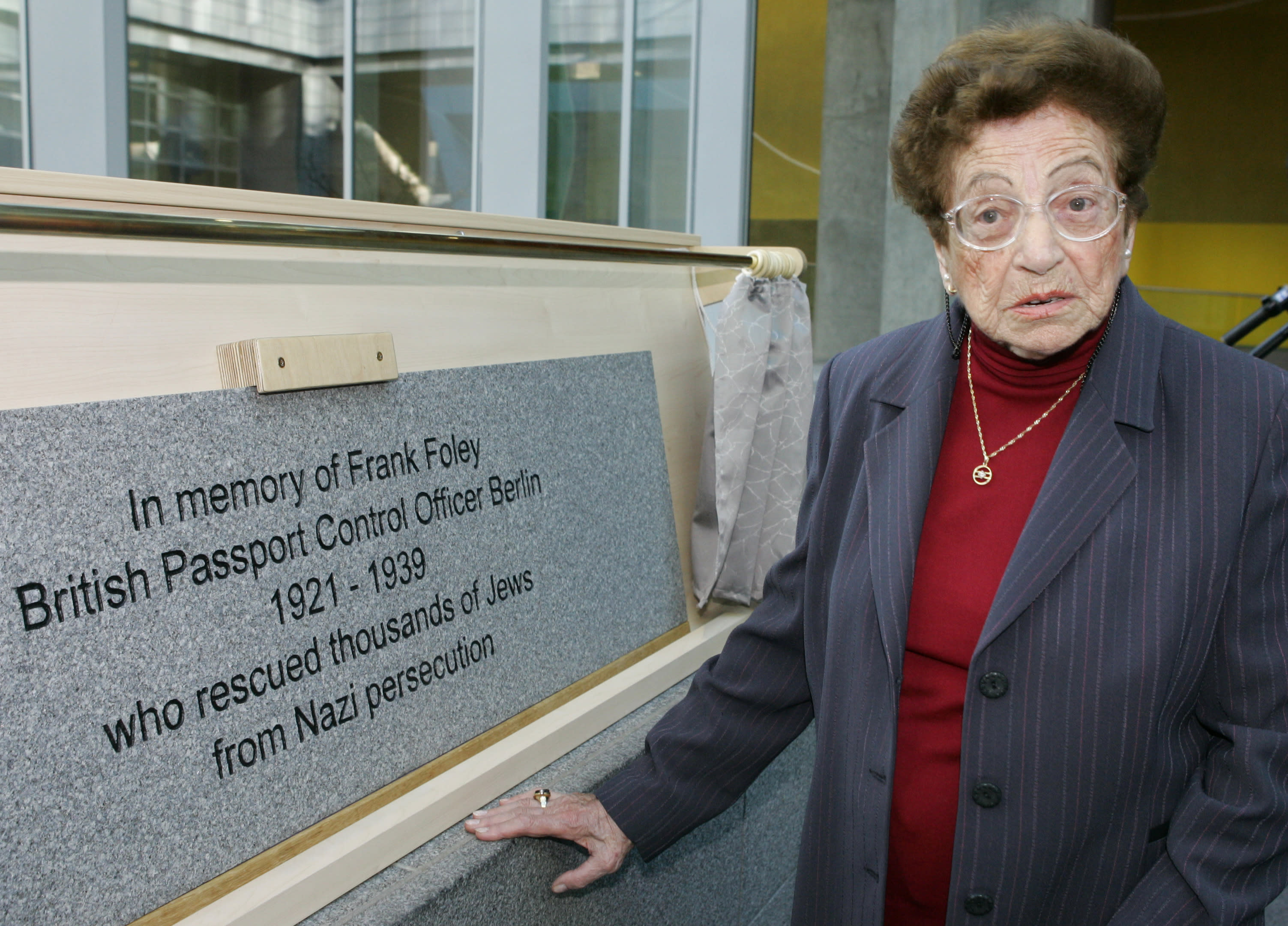 Elisheva Lernau, a Jewish refugee, stands next to a plaque commemorating Frank Foley at the British embassy in Berlin November 24, 2004 (Reuters)