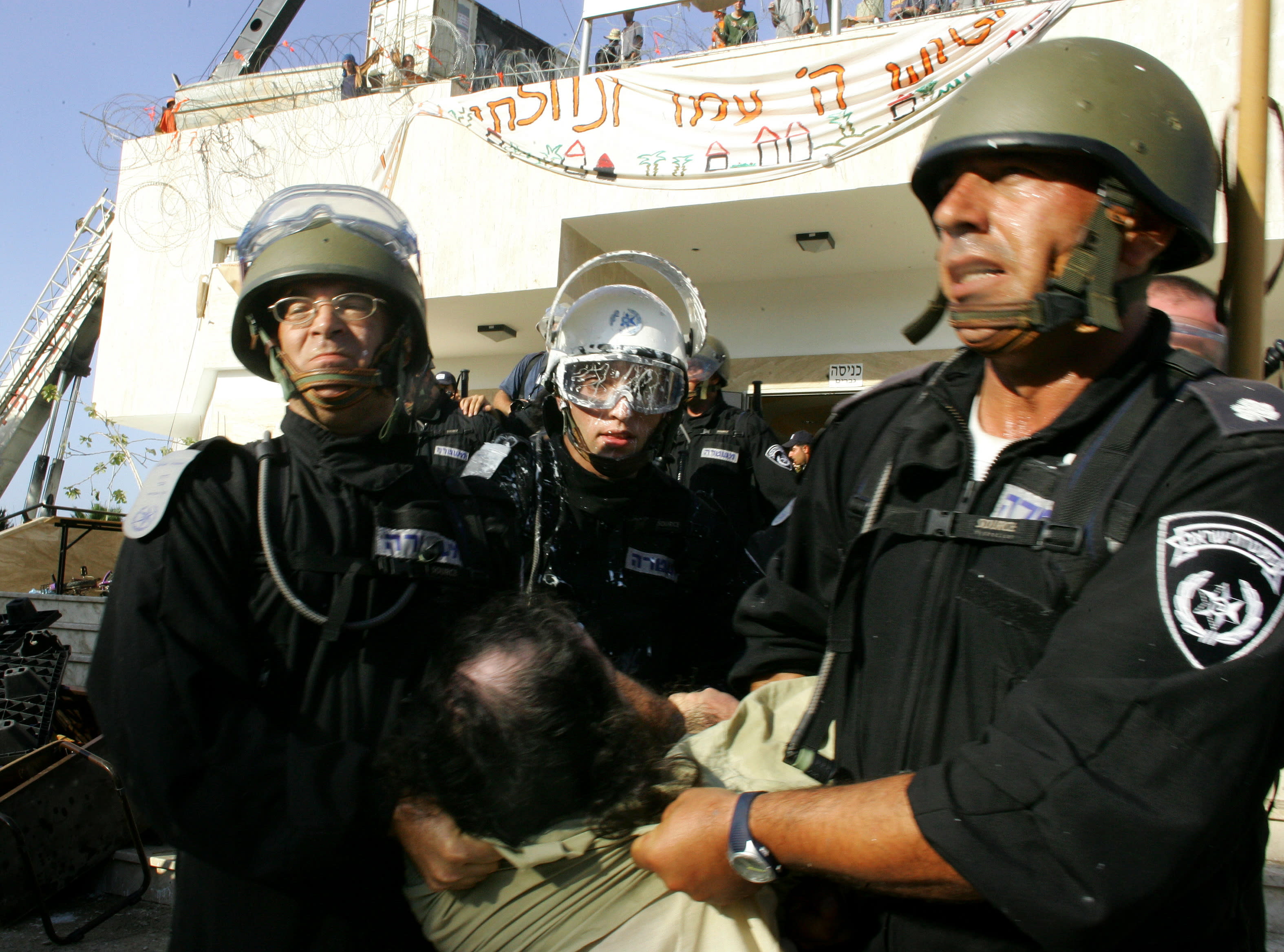 Israeli security forces drag a protester opposing Israel's disengagement plan from Gaza, in the Jewish settlement of Kfar Darom in the southern Gaza Strip, August 18, 2005 (Reuters)