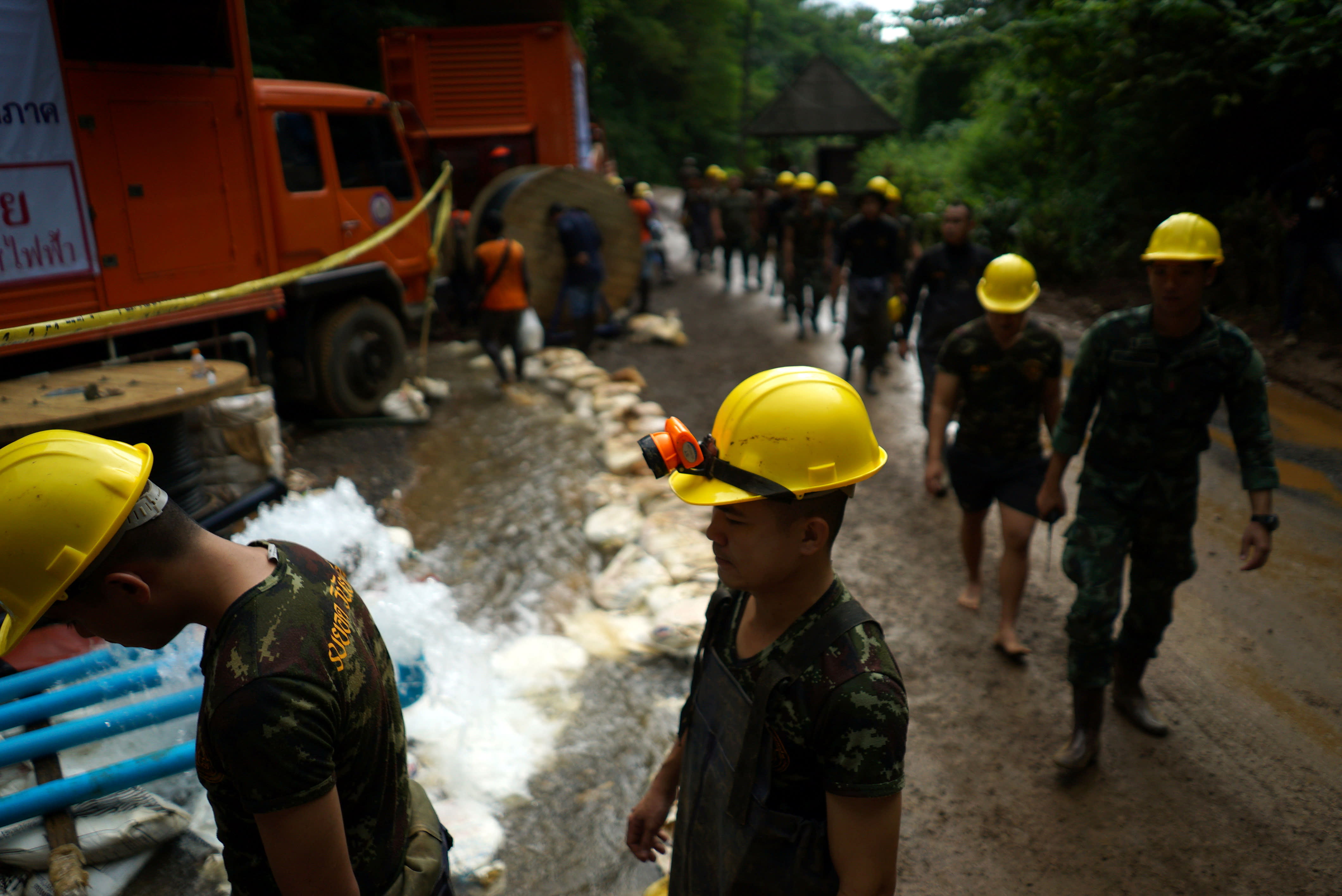Military personnel walk in line as they prepare to enter the Tham Luang cave complex, where 12 boys and their soccer coach are trapped, in the northern province of Chiang Rai, Thailand, July 6, 2018 (REUTERS/Athit Perawongmetha)