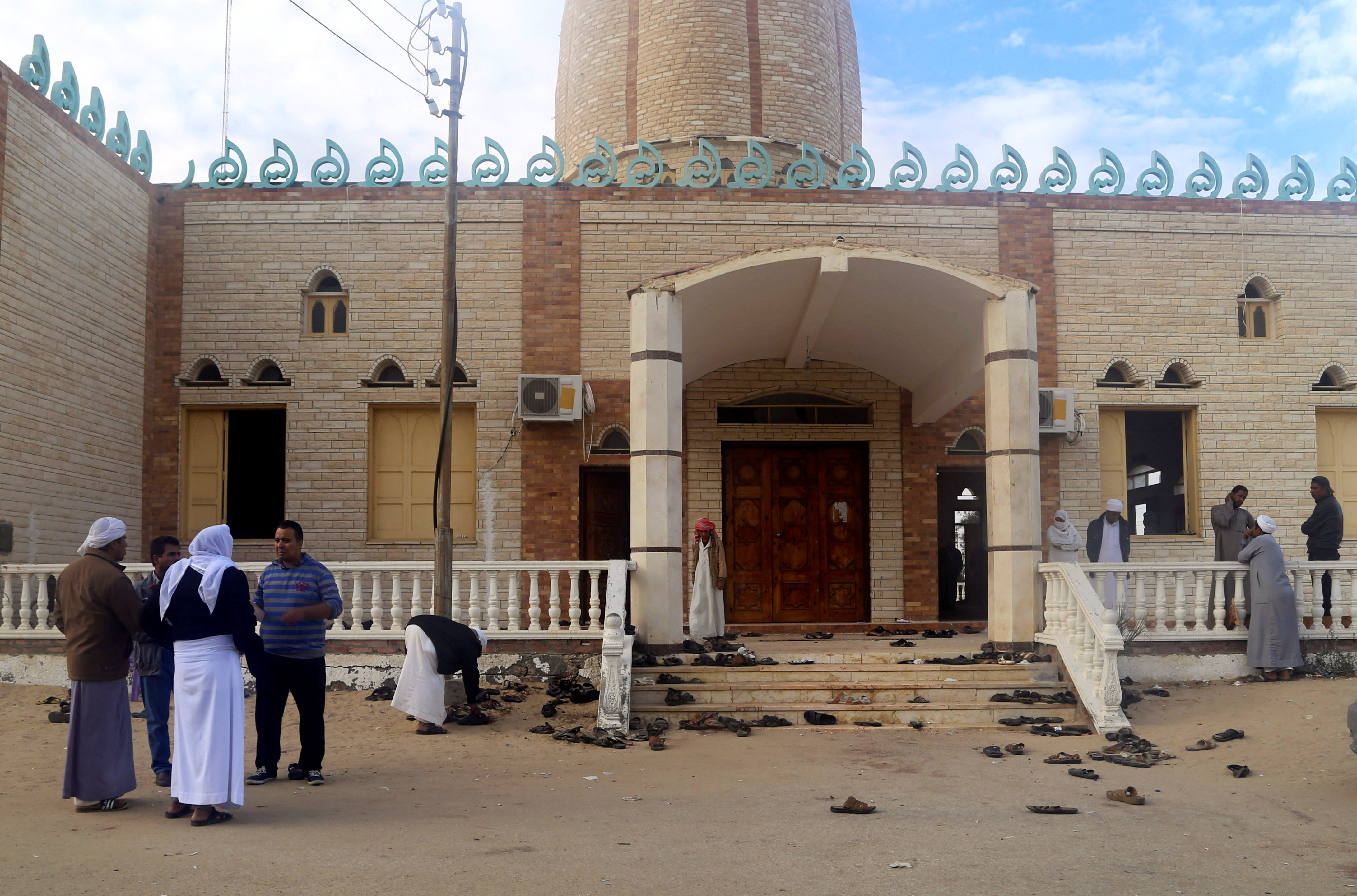 People stand outside Al Rawdah mosque, where a bomb exploded, in Bir Al-Abed, Egypt November 25, 2017 (Reuters)
