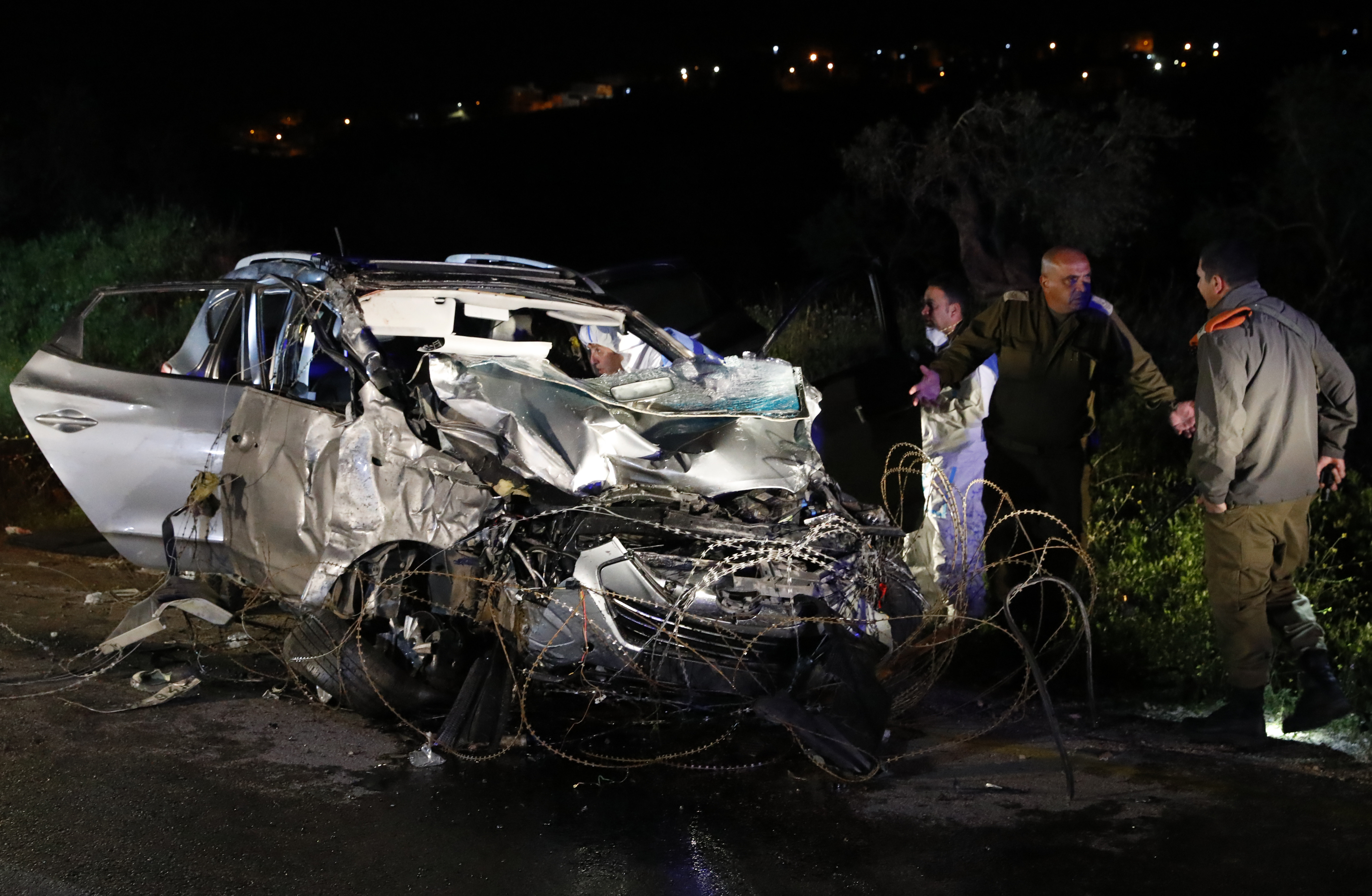 Israeli security forces inspect the vehicle that was used by a Palestinian assailant in a car ramming attack in the West Bank on March 16, 2018. (JACK GUEZ / AFP)