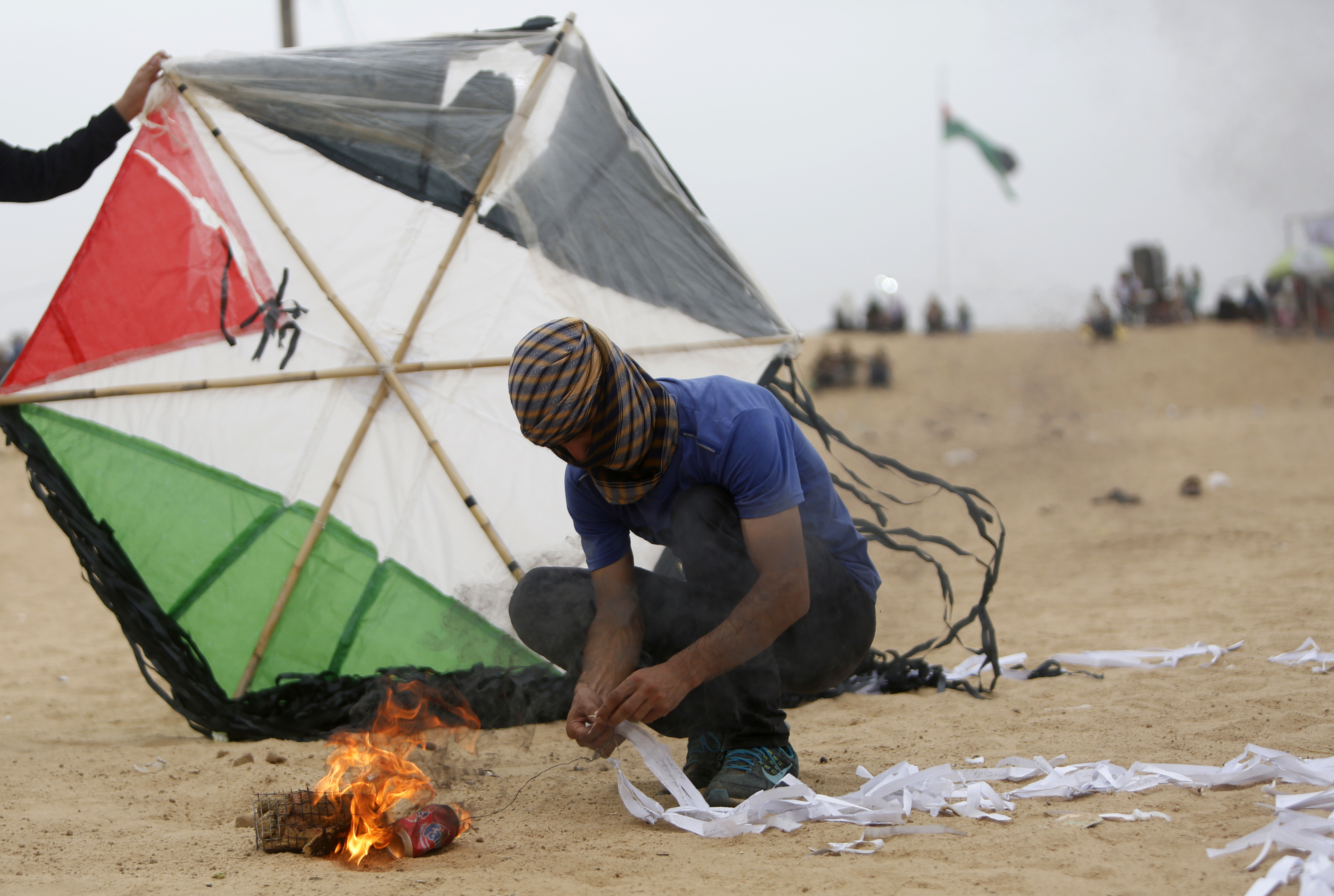 Palestinians prepare an incendiary device attached to a kite before trying to fly it over the border fence with Israel, on the eastern outskirts of Jabalia, on May 4, 2018. (MOHAMMED ABED / AFP)