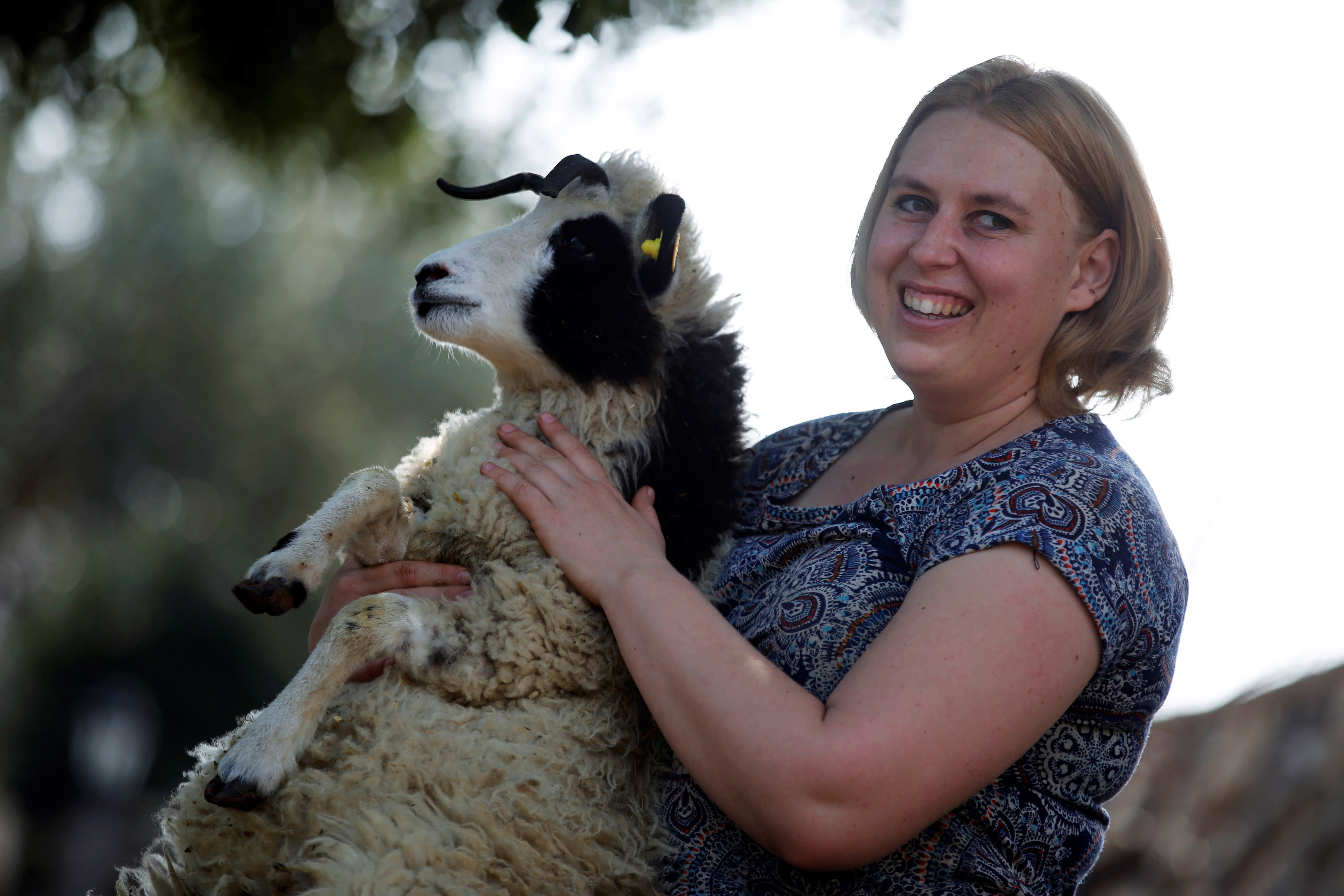Shepherdess Jenna Lewinsky holds a lamb from the Jacob sheep breed, in Ramot Naftali, Israel, February 21, 2018. (Reuters/Amir Cohen)