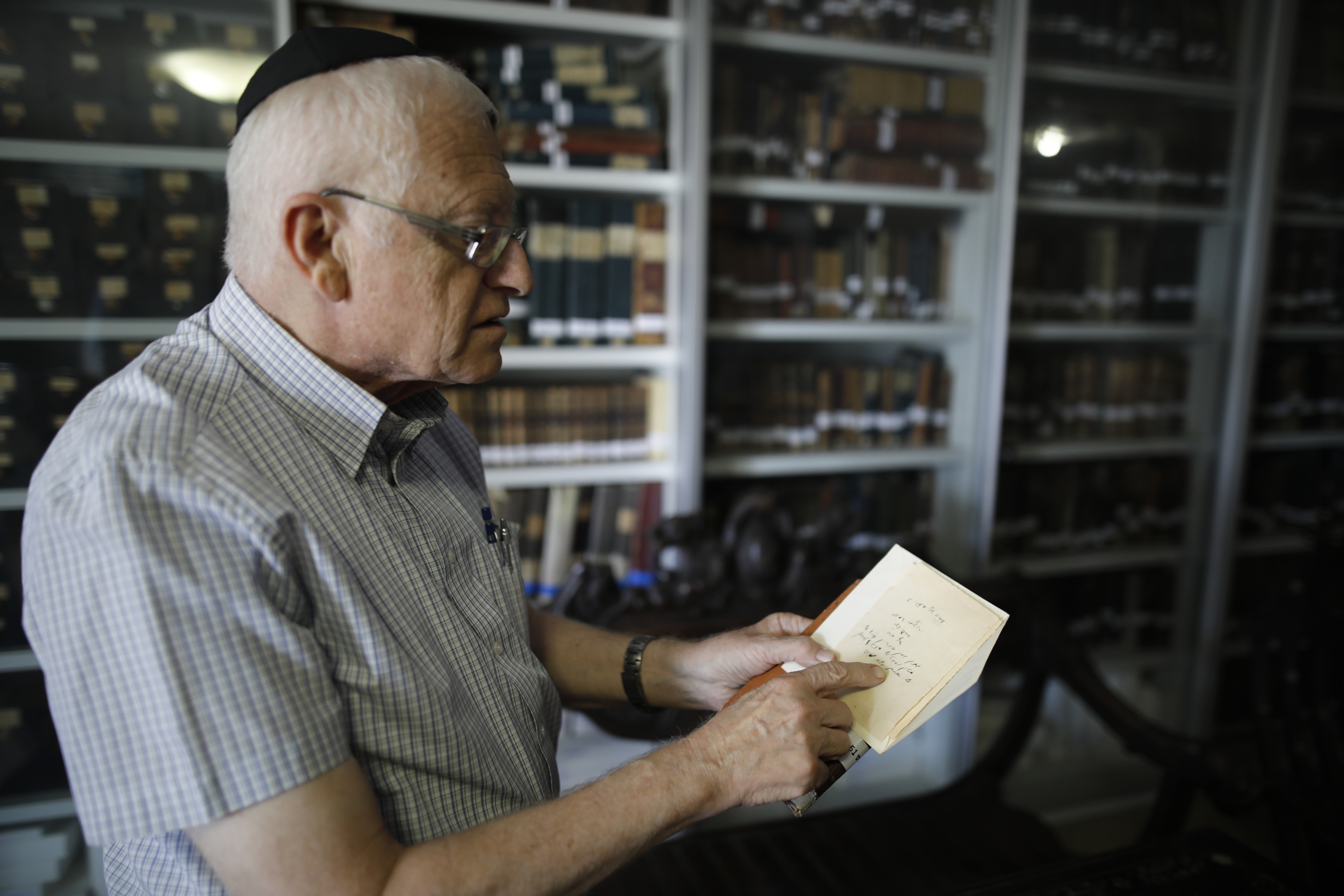 Gabriel Birnbaum shows old notes written by Eliezer Ben Yehuda, considered the father of modern Hebrew, on August 23, 2017. (MENAHEM KAHANA / AFP)