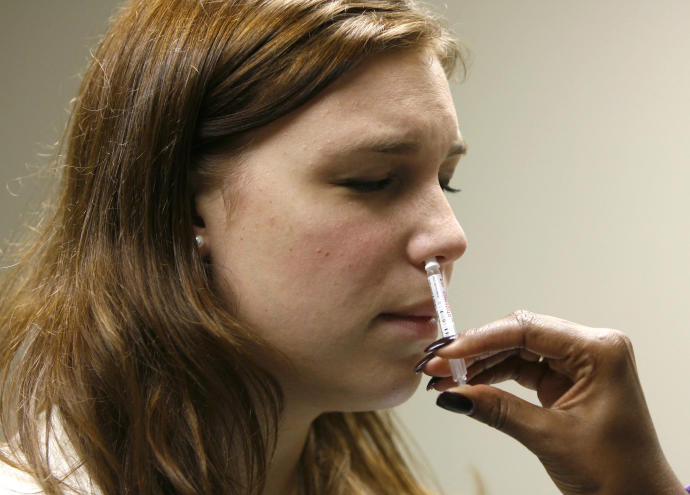 George Washington University student Jessica Hirsh is given the H1N1 flu nasal spray vaccine at the Student Health Service clinic in Washington, November 19, 2009 (REUTERS/HYUNGWON KANG).