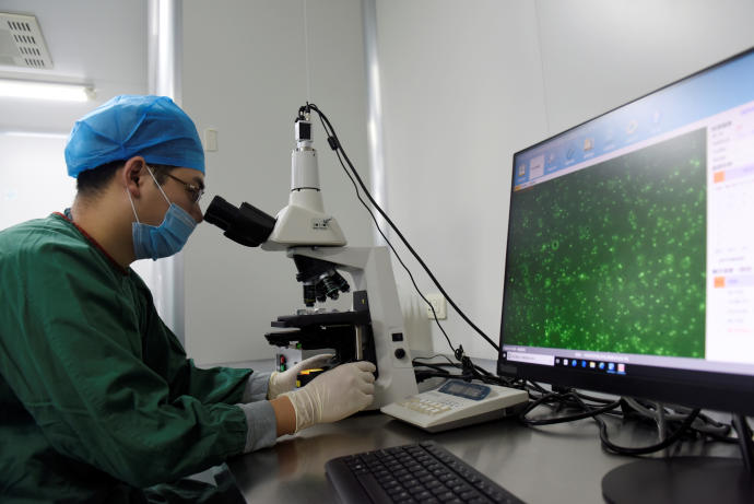 A technician inspects through a microscope a semen sample at a human sperm bank inside a hospital in Hefei, Anhui province, China February 21, 2019.REUTERS/STRINGER