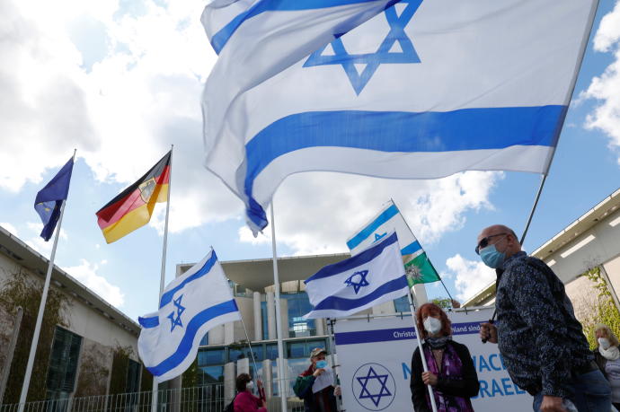 People wave the flags of Israel and the Trade Union of the Police outside the Chancellery in Berlin, Germany in May (Credit: REUTERS)