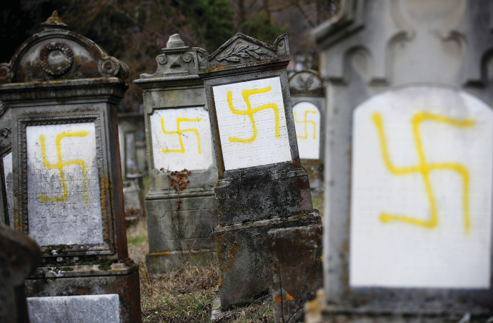 GRAVES DESECRATED with swastikas are seen in the Jewish cemetery in Quatzenheim, near Strasbourg, France, in 2019.VINCENT KESSLER/ REUTERS