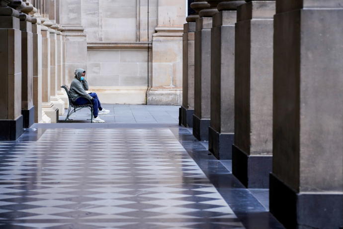 A lone man wearing a protective face mask sits at an unusually quiet State Library on the first day of a lockdown as the state of Victoria looks to curb the spread of a coronavirus disease (COVID-19) outbreak in Melbourne, Australia, July 16, 2021.REUTERS/SANDRA SANDERS/FILE PHOTO