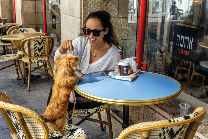DRAMATIC CHANGES ahead: Grabbing a bite with a furry friend at a Jerusalem Aroma. NATI SHOHAT/FLASH90