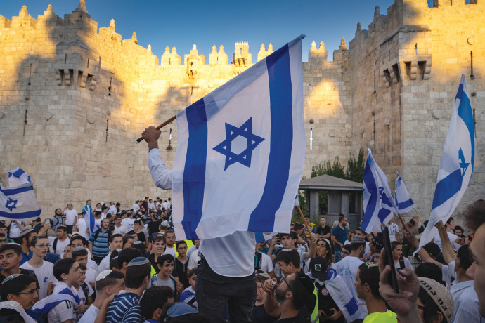 CELEBRANTS HOLD Israeli flags and dance during the March of Flags at the Damascus Gate in the Old City of Jerusalem in June. (Credit: OLIVIER FITOUSSI/FLASH90)