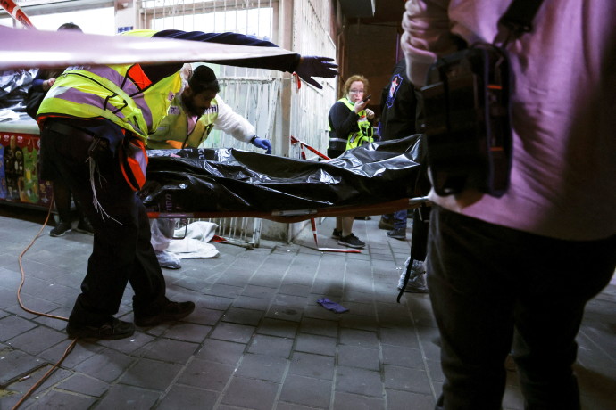 Israeli medical personnel and rescue workers evacuate a body from the scene of a fatal shooting attack on a street in Bnei Brak, near Tel Aviv, Israel, March 29, 2022. (Credit: NIR ELIAS/REUTERS)