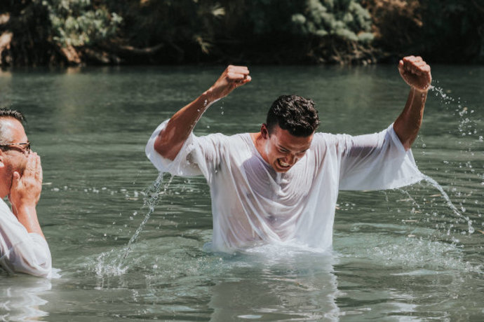 A Christian with Passages being baptized in the Jordan river (Credit: Courtesy / ALL ISRAEL NEWS)