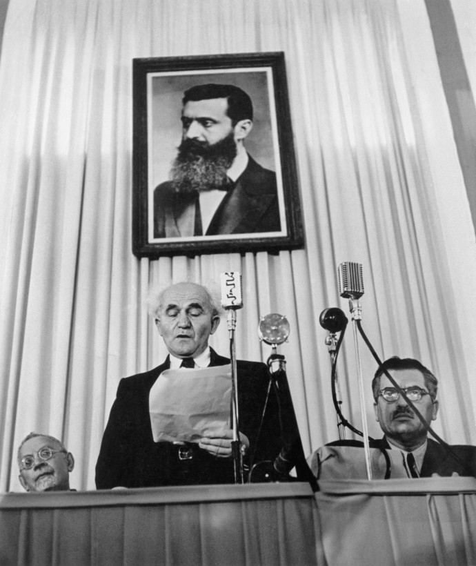 DAVID BEN-GURION reads the proclamation establishing Israel as an independent nation, Tel Aviv, May 14, 1948.  (Credit: © Robert Capa / ICP / Magnum Photos, Courtesy °CLAIRbyKahn)