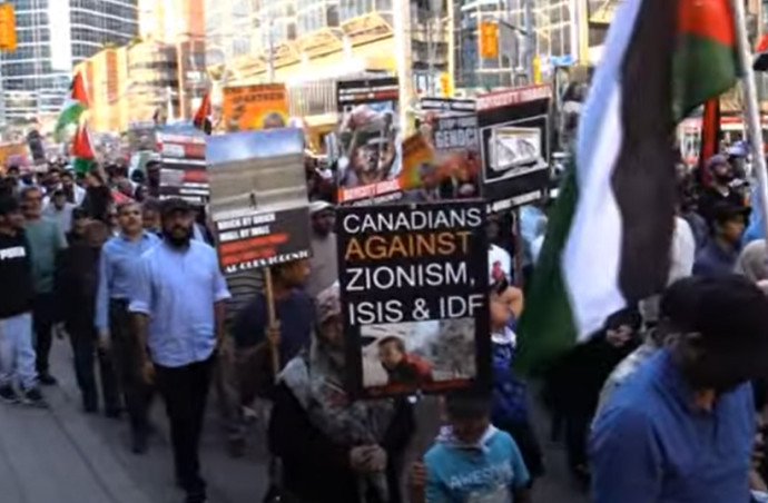 A child carrying a sign equating Zionism and the IDF to ISIS during Toronto’s 2023 Al Quds parade (Credit: YouTube)