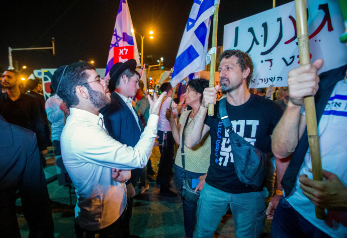 Demonstrators argue with Ultra orthodox jews during a protest march in Bnei Brak, against the billions in funds provided to ultra-Orthodox parties in the state budget, on May 17, 2023. (Credit: FLASH90)