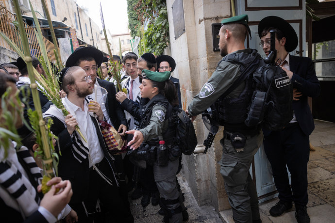 Israeli border police stand guard near orthodox Jews in the Jerusalem Old City Christian quarters, following yesterday's incident when ultra orthodox Jews spat at a Christian procession carrying a cross through Jerusalem's Old City. The same event occured today, October 4, 2023 (Credit: Chaim Goldberg/Flash90)