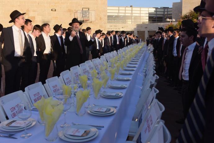 The Hostage Table in the Yeshiva world: By an empty table with seats for the hostages, hundreds of Nehora Yeshiva students read Psalms for their release (Credit: YOSSI ZELIGER)
