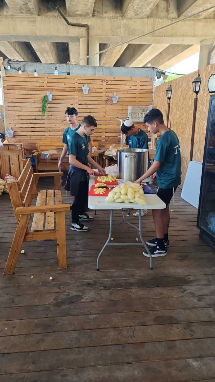 Israeli teens from disadvantaged backgrounds prepare food for Israeli soldiers. (Credit: Courtesy of Merchavim Institute)