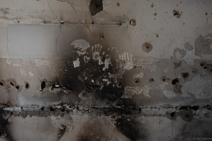‘BEARING WITNESS,’ 2023. The scorched wall, pockmarked with bullet holes, bears witness to the harrowing struggle for survival endured by the 17 people trapped within its confines. (Credit: CHEN SCHIMMEL)