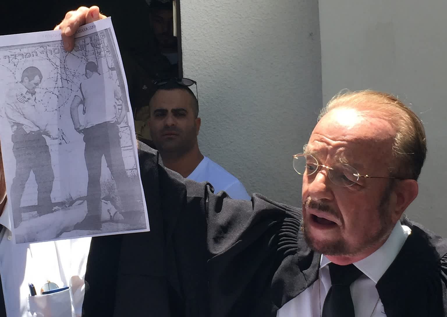 Azaria's attorney, Yoram Sheftel holding up a sign depicting a similar incident to his client's (credit: Anna Ahronheim)