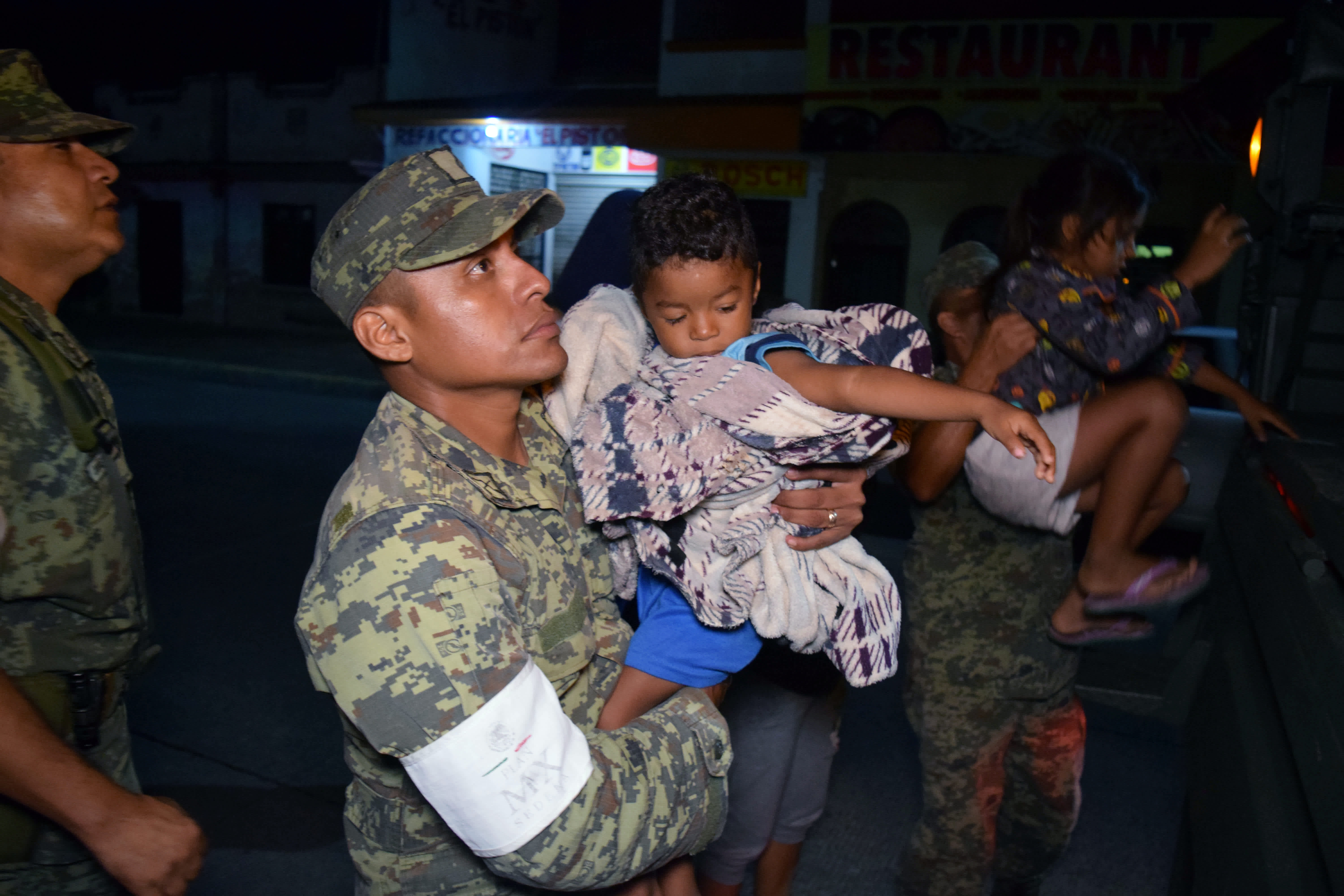 Soldiers help children to get on a truck as residents are being evacuated from their coastal town after an earthquake struck off the southern coast, in Puerto Madero, Mexico. Jose Torres / Reuters