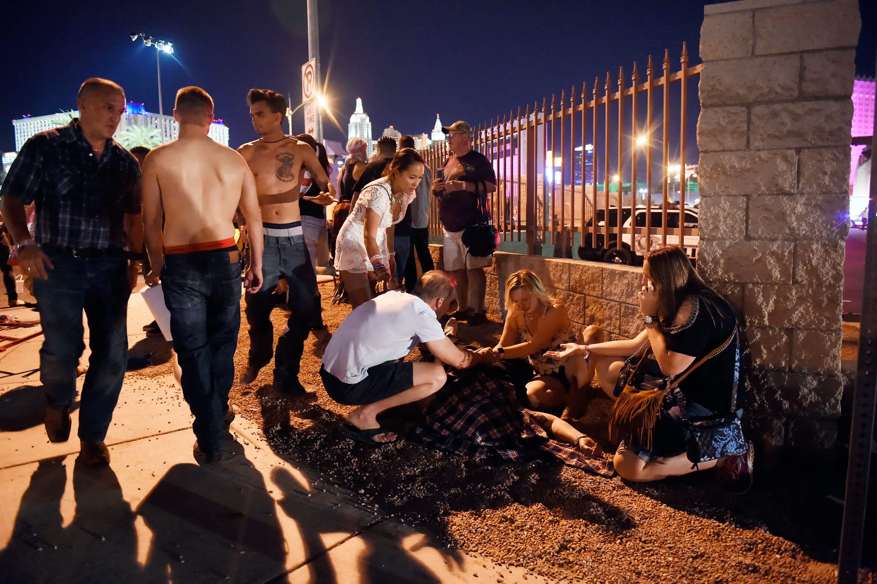 People tend to the wounded outside the scene of a mass shooting at a music festival in Las Vegas (DAVID BECKER / GETTY IMAGES / AFP)
