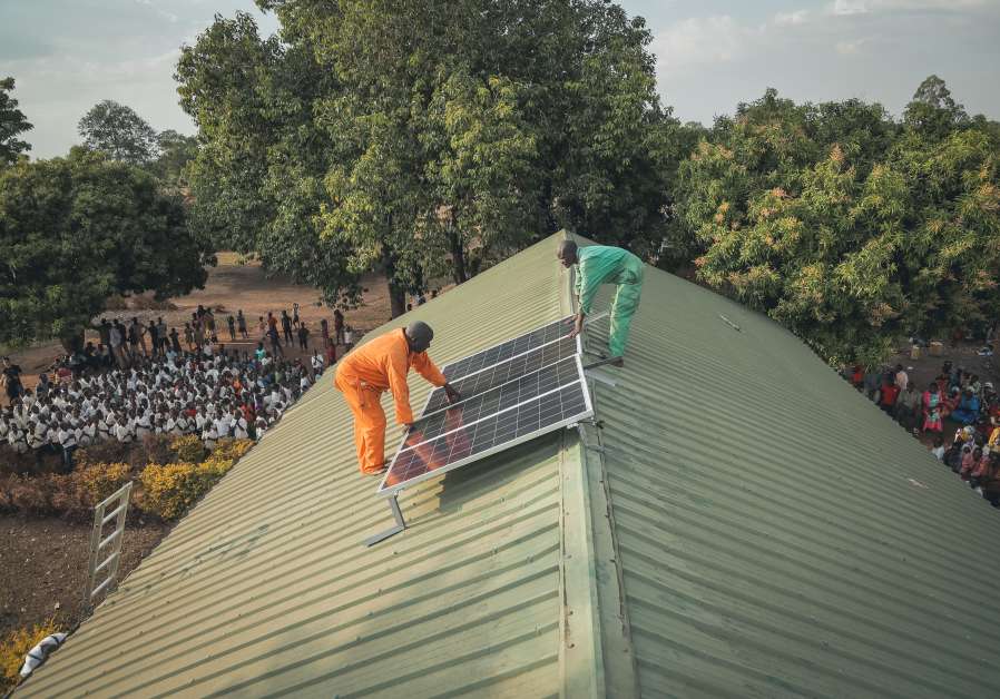 People of Ínnovation: Africa' install solar panels on the roof of Nyanza Primary School. (Credit: Lior Sperandeo).
