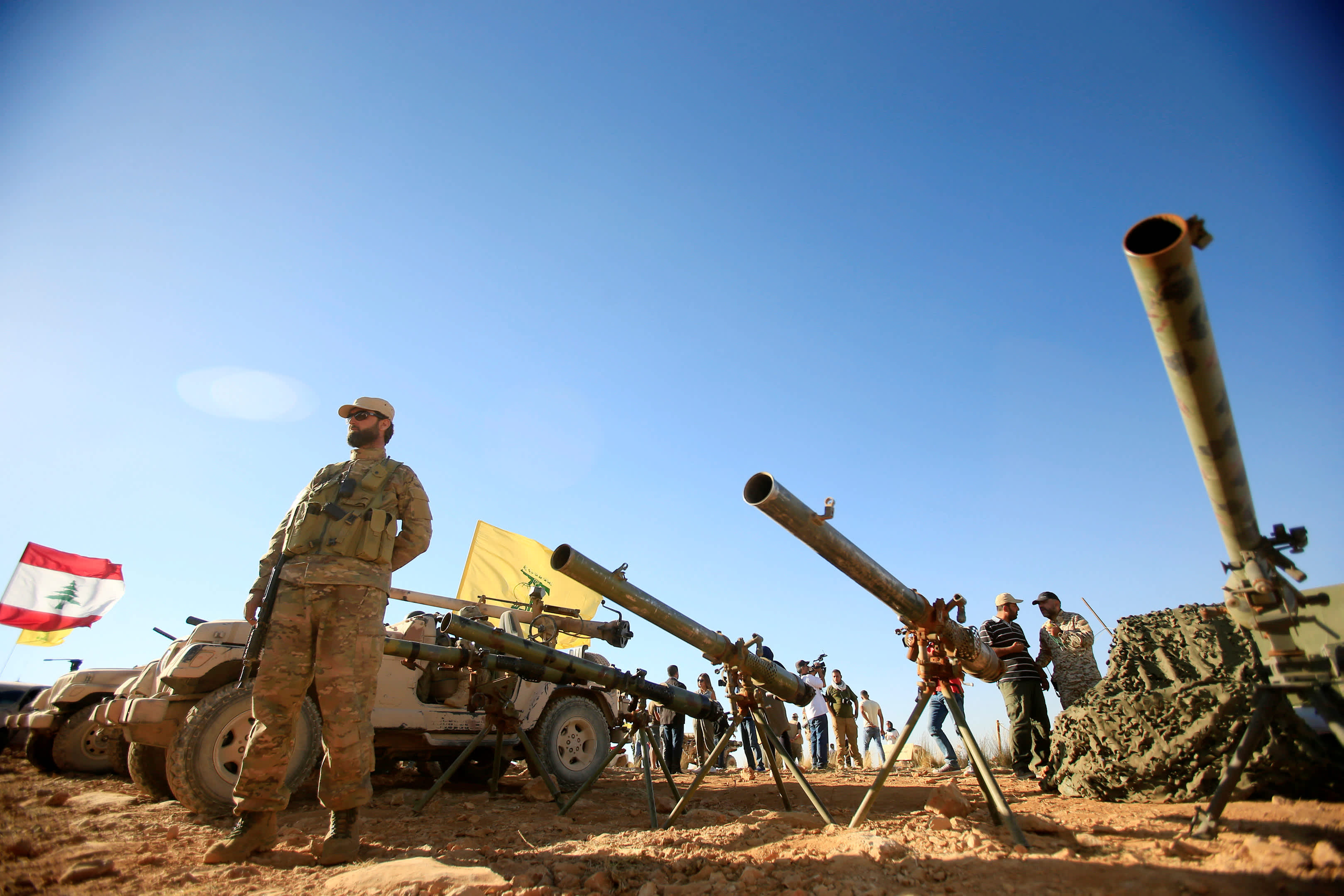 A Hezbollah fighter stands in front of anti-tark artillery at Juroud Arsal, the Syria-Lebanon border (Reuters)