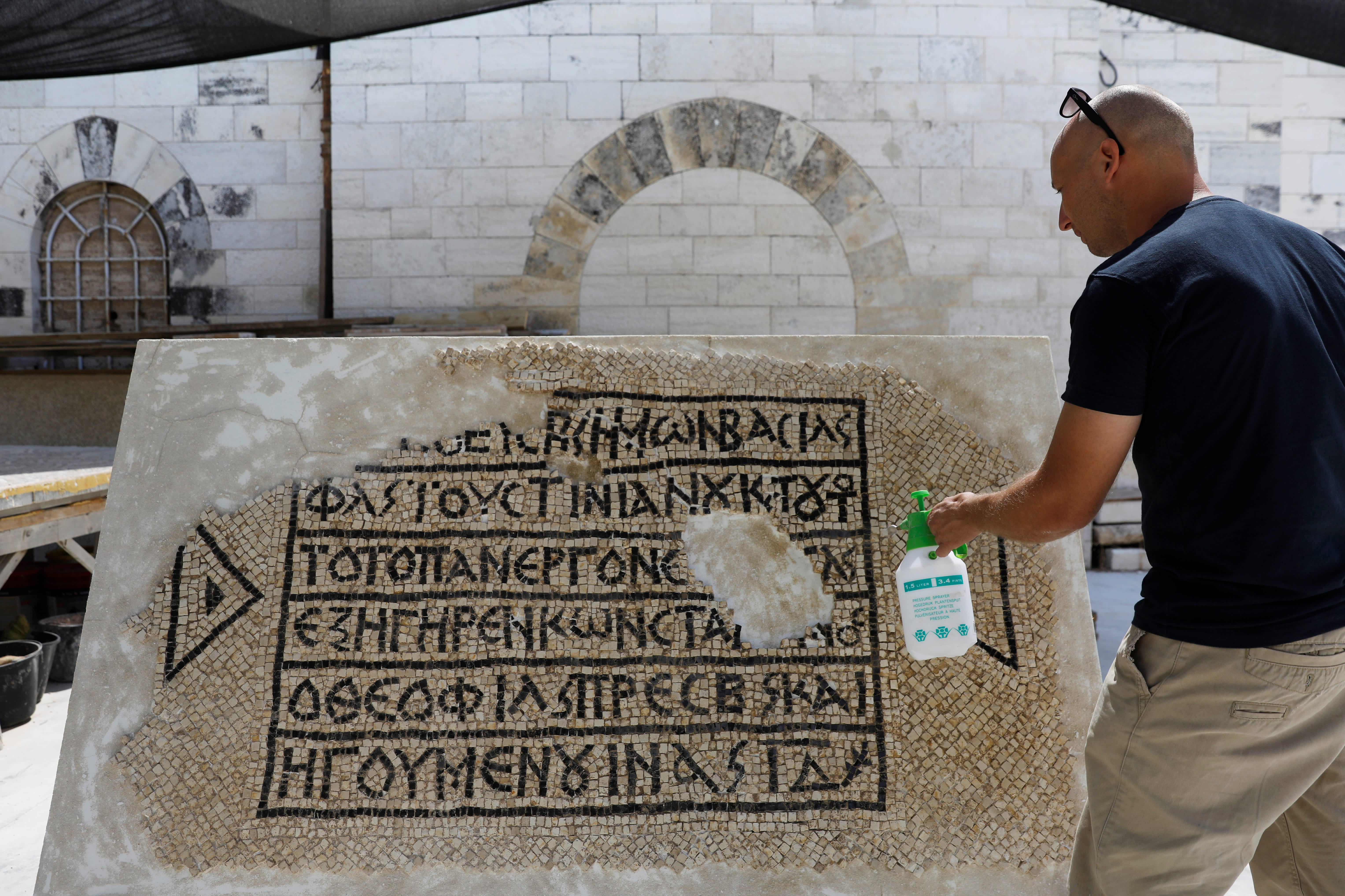 A conservationist works on a 1500-year-old mosaic floor bearing a Greek writing, discovered near Damascus Gate in Jerusalem's Old City, August 23, 2017 (Reuters/Ronen Zvulun)
