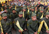 Lebanon's Hezbollah members hold party flags as they listen to their leader Sayyed Hassan Nasrallah 