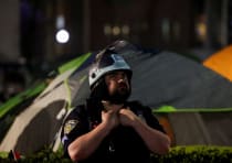  An NYPD law enforcement official stands guard near student encampment at Columbia U.