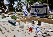 Bereaved Israelis seen at the Mount Herzl military cemetery, in Jerusalem, May 12, 2024