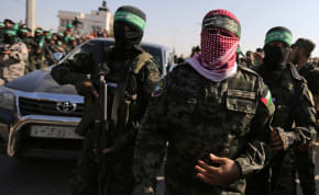 Abu Ubaida, the spokesman of the Izz el-Deen al-Qassam Brigades, walks during an anti-Israel military show by Hamas militants in the southern Gaza Strip