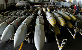  Aviation ordonancemen stand next to JSOW (Joint Standoff Weapon) (left) and JDAM satellite guided bombs (right) aboard the USS Kitty Hawk aircraft carrier in the northern Gulf April 9, 2003