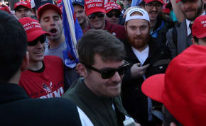 Supporters of the America First ideology and US President Donald Trump cheer on Nick Fuentes, a leader of the America First movement and a white nationalist, as he makes his way through the crowd for a speech during the "Stop the Steal" and "Million MAGA March" protests, November 14, 2020.