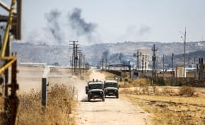  Israeli military jeeps drive on a road leading from a raid on Jenin refugee camp, as seen from Salem checkpoint, the entrance from Israel to Jenin in the West Bank, on July 3, 2023.
