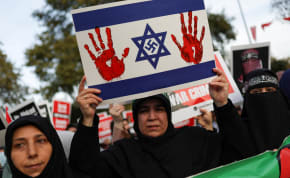  A pro-Palestinian demonstrator holds a sign, as they take part in a protest against US Secretary of State Antony Blinken's visit to Turkey, amid the ongoing conflict between Israel and Hamas, in Istanbul, November 4, 2023.