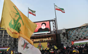  A CROWD in Tehran watches an address, on the screen by Hezbollah leader Hassan Nasrallah, in November. Hezbollah is virtually a state within a state, sucking the lifeblood out of Lebanon at the instigation of Iran, says the writer.