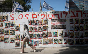  People walk by pphotographs of  Israelis still held hostage by Hamas terrorists in Gaza, at "Hostage Square" in Tel Aviv. March 10, 2024. 