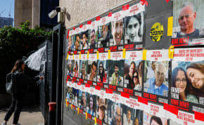  A woman stands next to posters with photos of hostages kidnapped in the deadly October 7 attack on Israel by the Palestinian Islamist group Hamas from Gaza, in Tel Aviv, Israel March 20, 2024. 