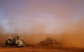  An Israeli armoured personnel carrier (APC) and an Israeli tank participate in a drill near Israel's border with Lebanon in northern Israel, October 26, 2023.