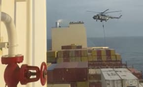  An official slides down a rope during a helicopter raid on MSC Aries ship at sea in this screen grab obtained from a social media video released on April 13, 2024. 