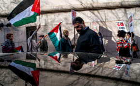 A man passes by as demonstrators attend a protest outside Columbia University, as the protest encampment continues in support of Palestinians, amid ongoing conflict between Israel and the Palestinian Islamist group Hamas, in New York City, U.S., April 23, 2024.