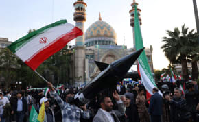  Iranians carry a model of a missile during a celebration following the IRGC attack on Israel, in Tehran, Iran, April 15, 2024. 
