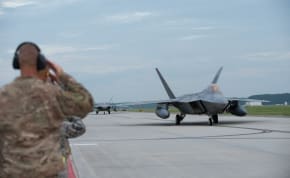  Maintainers and senior leaderships from the 1st Fighter Wing salute F-22 Raptors from the 1st Fighter Wing, 27th Fighter Squadron as it taxis to take-off during a deployment to Al Udeid Air Base, Qatar, from Joint Base Langley-Eustis, Virginia, U.S 