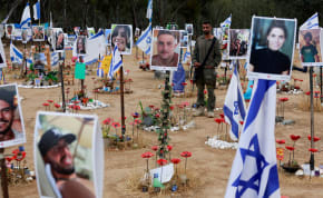  An Israeli soldier stands during a two-minute siren marking the annual Israeli Holocaust Remembrance Day, at an installation at the site of the Nova festival where party goers were killed and kidnapped during the October 7 attack by Hamas terrorists from Gaza, in Reim, southern Israel, May 6, 2024.